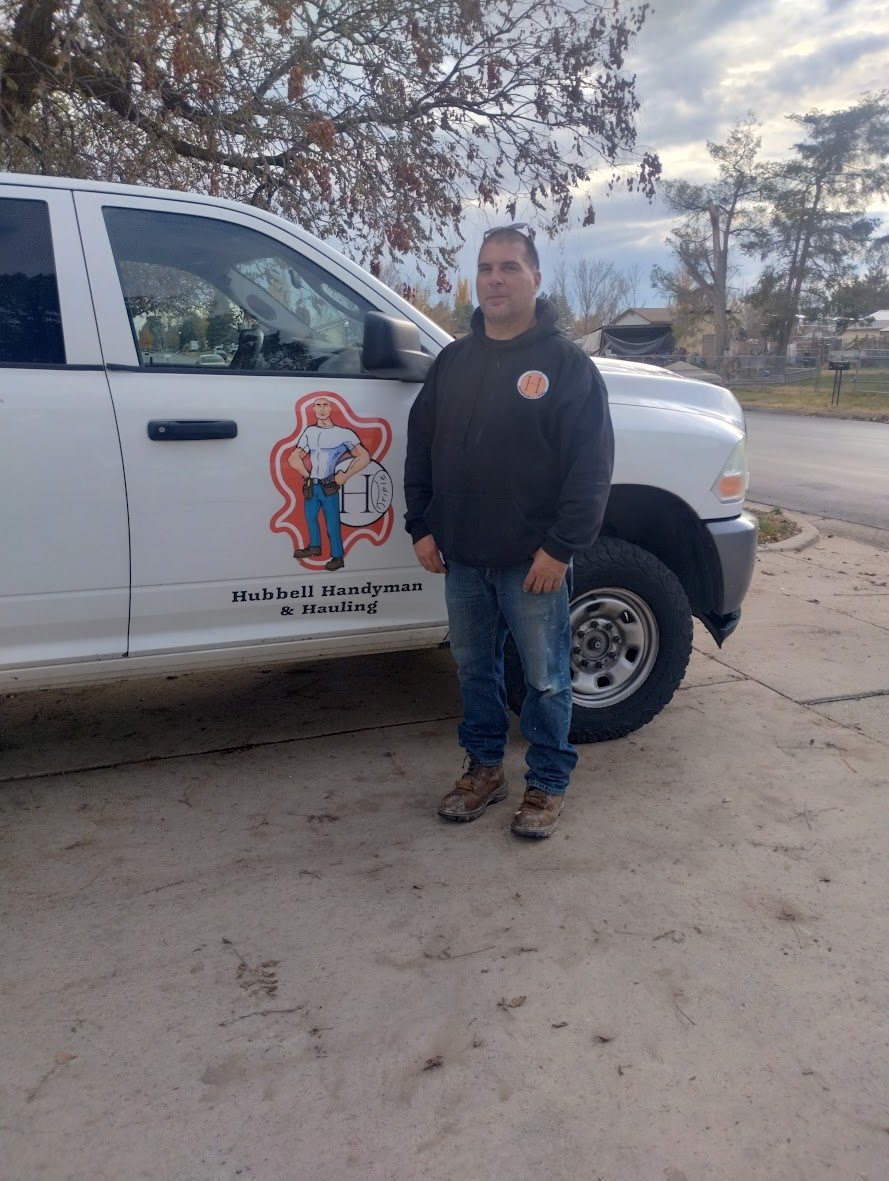 Eric Hubbell, owner of Hubbell Handyman and Hauling, standing next to his work truck